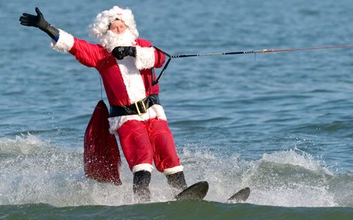 A man dressed as Santa Claus water skis on the Potomac River at the National Harbor in Prince George's County, Maryland, near Washington, DC, on December 24, 2009. Joined by flying elves, Frosty the Snowman in a dinghy and kneeboarding reindeer, Santa celebrates his 24th anniversary of water-skiing in the Washington area on Christmas Eve.